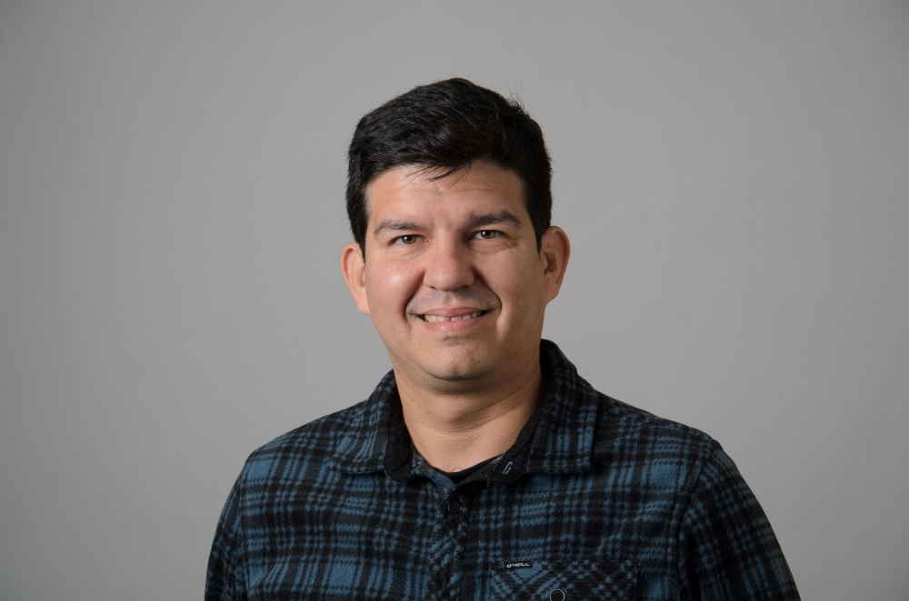 Portrait of Felipe Soares with a blue and black plaid shirt.